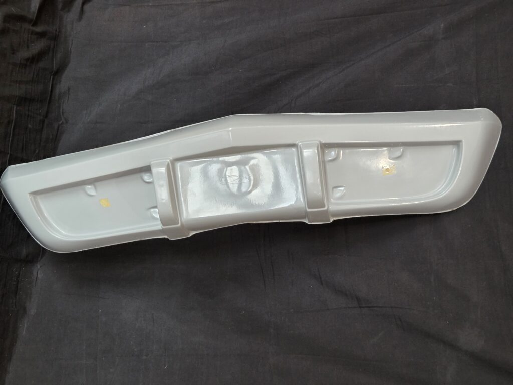 White plastic panel resting on black fabric