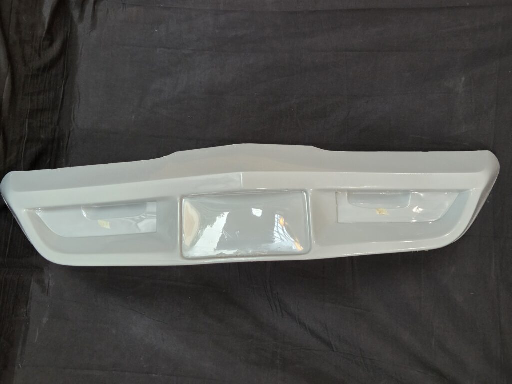 White car bumper on black fabric background