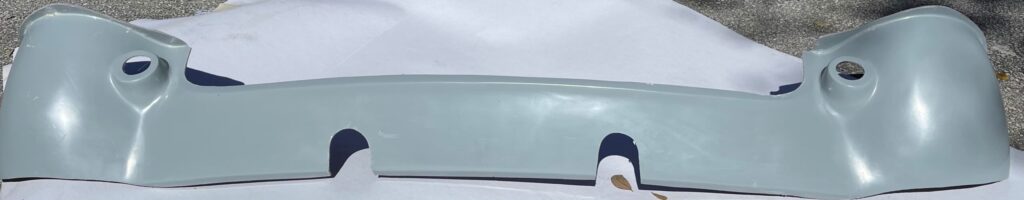 Close-up of a car's windshield and side mirror on a cloudy day.