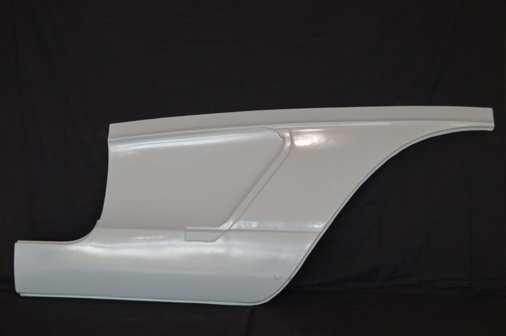 White car quarter panel against black backdrop