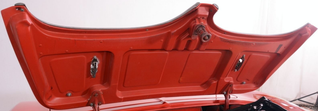 Underside of open red car trunk lid