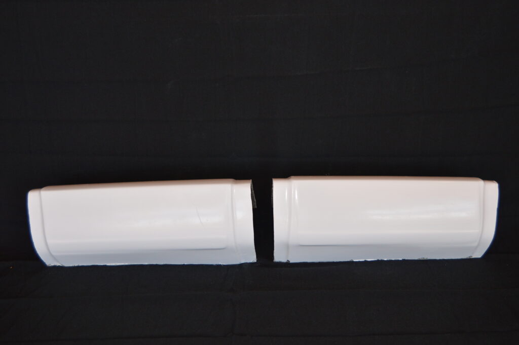 Two white curved plastic pieces on black