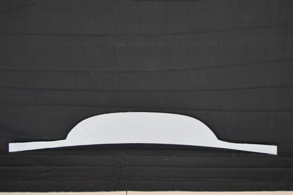 White curved paper template on black fabric