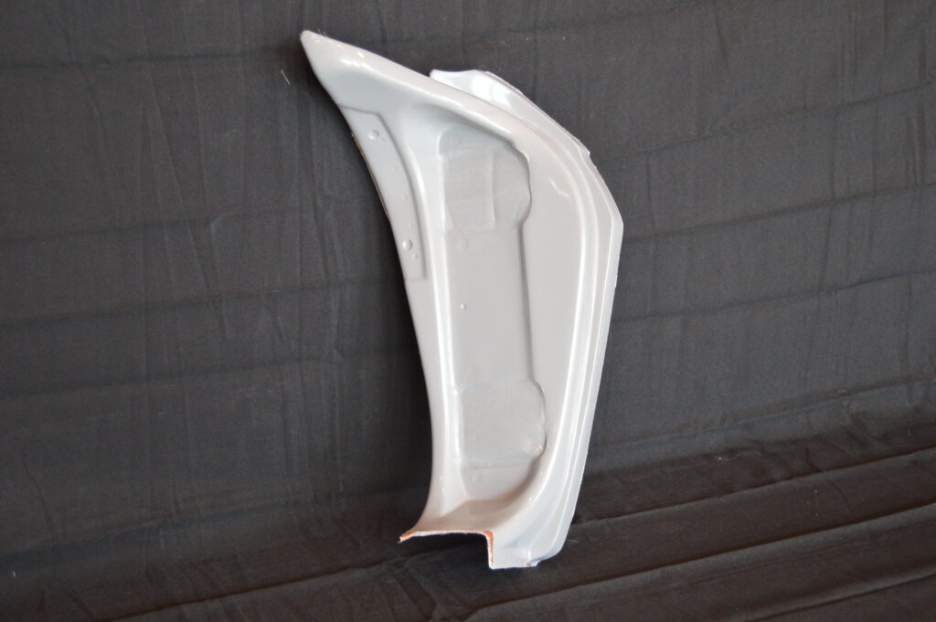 White car fender panel on black fabric