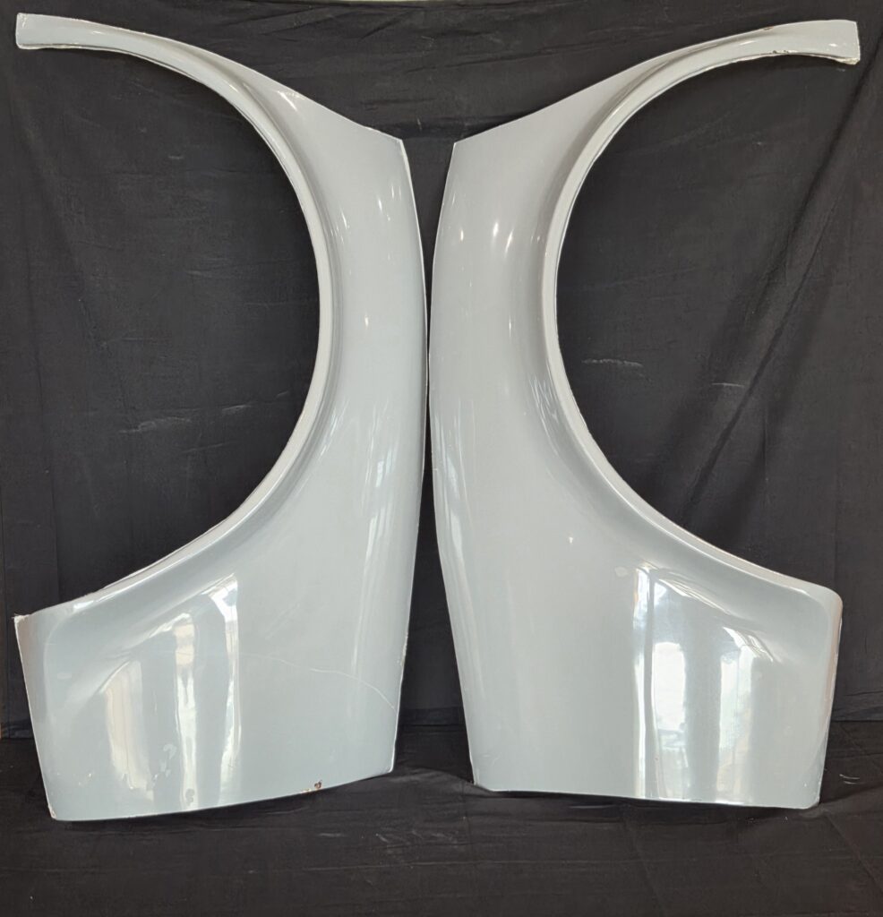 Two white curved vehicle body panels